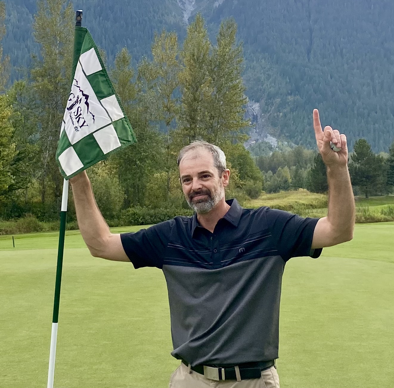 Bill McDonough holding up a green flag.